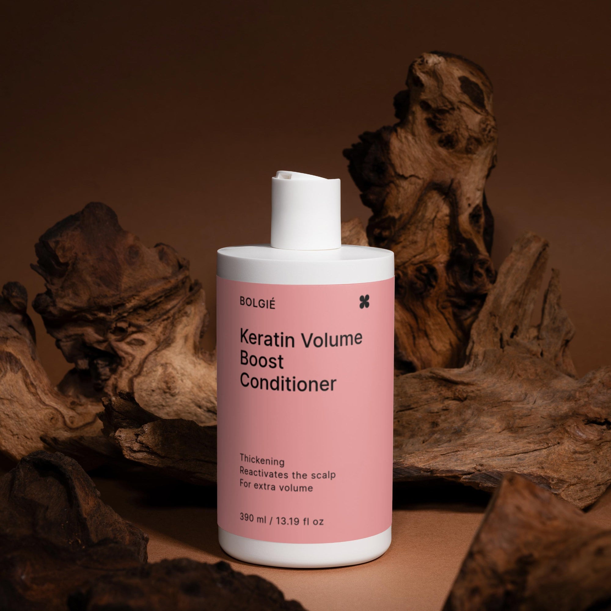 Keratin Volume Boost Conditioner bottle with pink label on a brown background